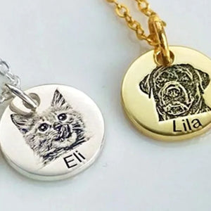 Gros plan sur deux médailles rondes gravées : un chat (Eli) en argenté et un chien (Lila) en doré