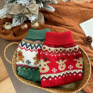 Deux pulls de Noël pour chien, rouge à rennes et vert à bonshommes pain d'épice, dans un panier
