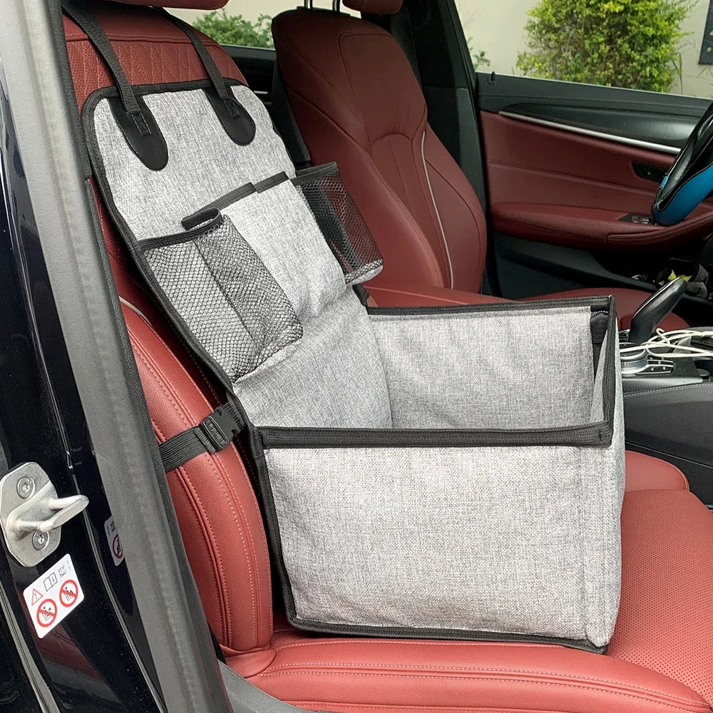 Panier rehausseur pour chien attaché au siège avant d'une voiture par ses sangles